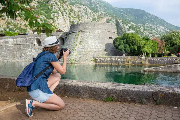 Chica Sombrero Con Una Mochila Una Cámara Toma Fotos Muralla —  Fotos de Stock