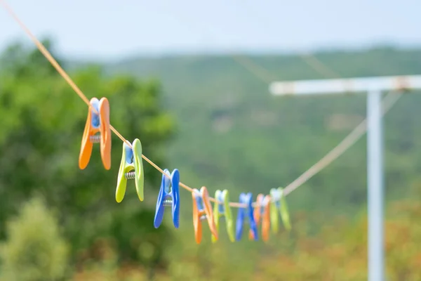 Colored clothespins hang on a rope in a row at a mountain landscape, Pyrenees, France