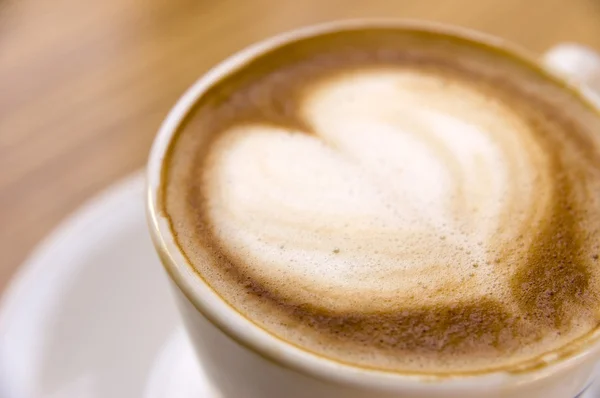 Een kopje cappuccino met schuim in de vorm van hart — Stockfoto