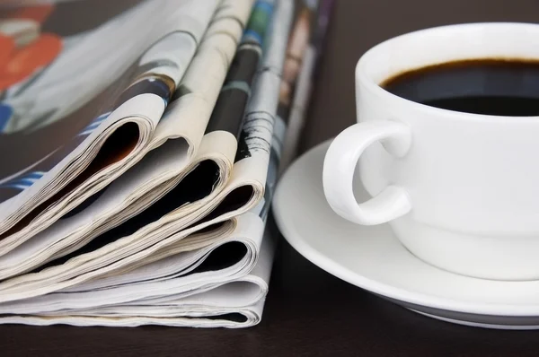 stock image pile of newspapers and cup of coffee on the table