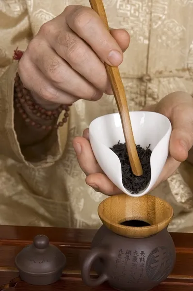 Tetera de relleno maestro de ceremonia de té con hojas de té —  Fotos de Stock