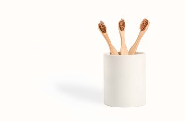 Bamboo toothbrush in white ceramic glass isolated on white background