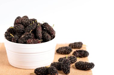 Beyaz arka planda beyaz seramik kasede taze organik dut meyvesi yakın