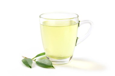 Cam fincanda yeşil çay ve beyaz arka planda izole edilmiş çay yaprağı..