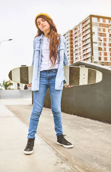 Meisje dat plezier heeft met skateboarden in skate park, Portret van lachende jonge vrouwelijke skateboarder die haar skateboard vasthoudt. Recreatief activiteitsconcept. — Stockfoto