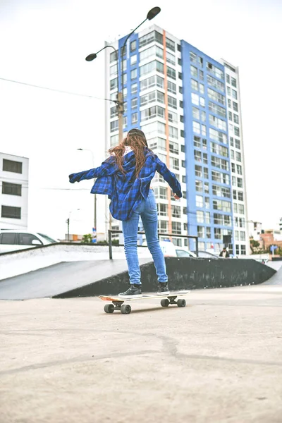 Meisje dat plezier heeft met skateboarden in skate park, Portret van lachende jonge vrouwelijke skateboarder die haar skateboard vasthoudt. Recreatief activiteitsconcept. — Stockfoto