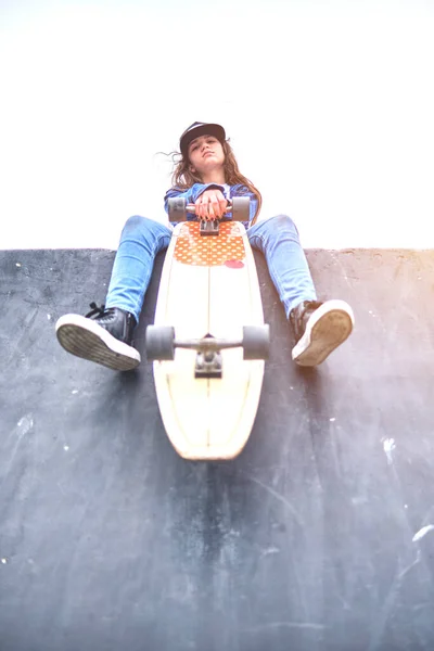 Chica que se divierte montando monopatines en el parque de skate, Retrato de una joven patinadora sonriente sosteniendo su monopatín. Concepto de actividad recreativa. — Foto de Stock