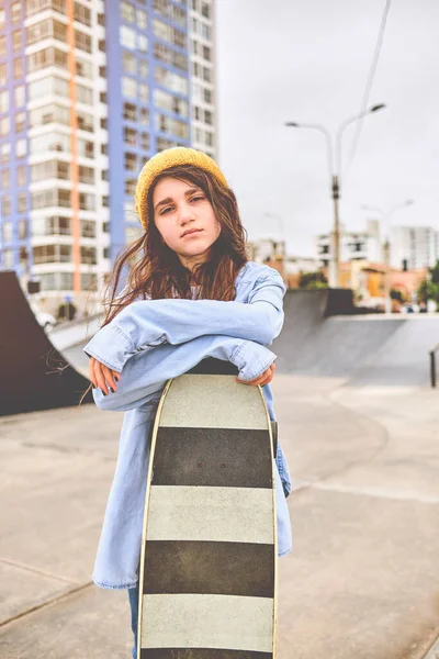 Dívka se baví jezdit na skateboardech v skate parku, Portrét usmívající se mladé ženy skateboardista drží její skateboard. Koncepce rekreační činnosti. — Stock fotografie