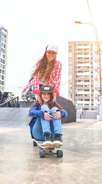 Atraktivní přítelkyně baví jízda na skateboardech v skate parku, Usmívající se portrét mladých skateboardistů drží její skateboard. — Stock fotografie