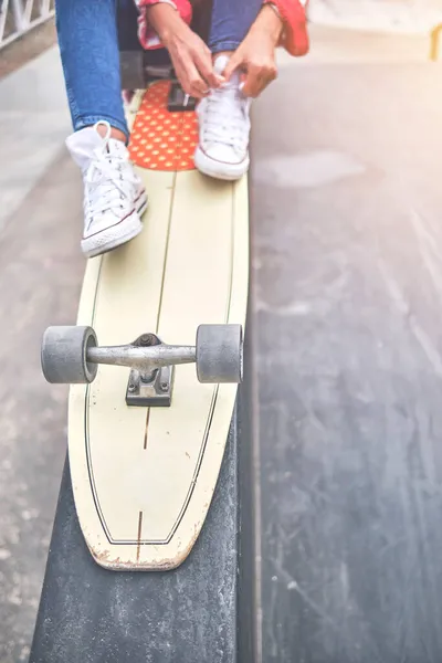 Skater meisje maakt zich klaar voor actie, strikken schoenveter. Eerste stap. Selectieve focus — Stockfoto