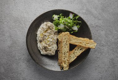 İtalyan peynirli stracciatella -bufalo mozzarella- taze roka ve kızarmış ekmekle servis edilen siyah tabakta. Şefin sunumu.