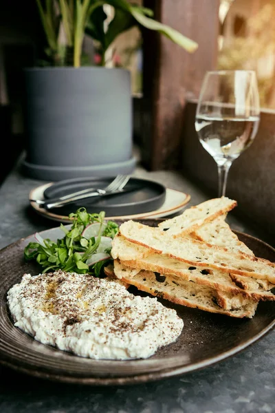 İtalyan peynirli stracciatella -bufalo mozzarella- taze roka ve kızarmış ekmekle servis edilen siyah tabakta. Şefin sunumu.