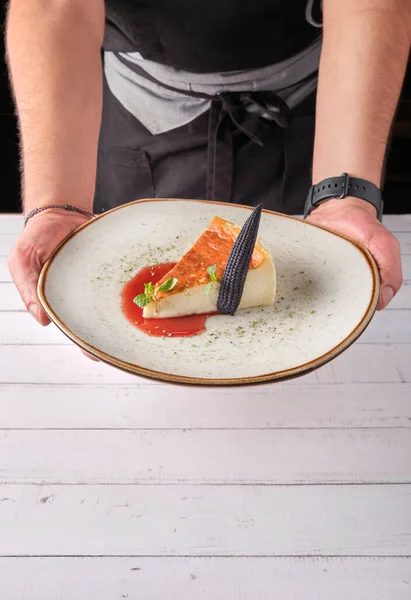 Szef kuchni prezentuje talerz nowojorskiego sernika lub klasycznego sernika ze świeżym, apetycznym zdrowym. — Zdjęcie stockowe