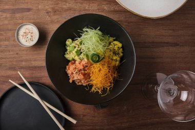 Poke kasesi, geleneksel Hawaii çiğ somon balığı salatası, yemek çubukları ve fotokopi alanı. Seçici odak.