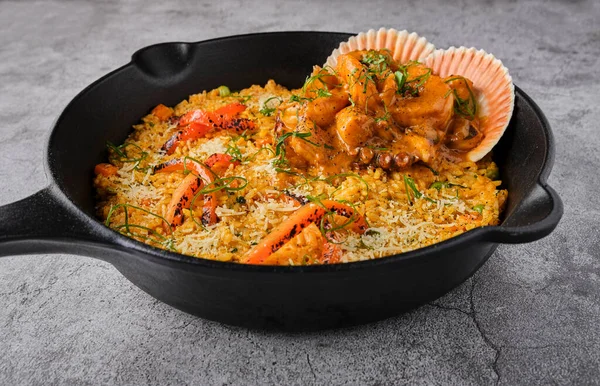 Deniz mahsullü pilav ve pilav. Arroz con Mariscos, tavada servis edilen yemek, seçici odaklanma.