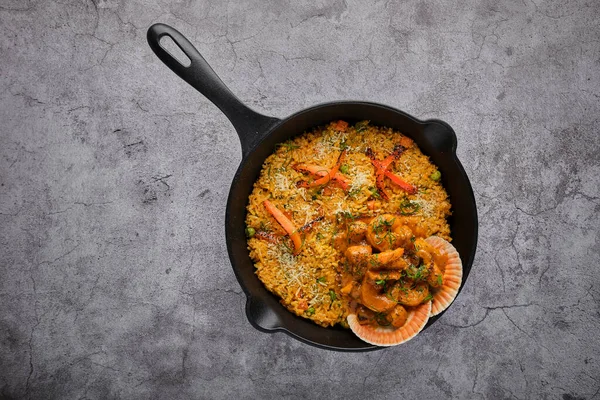 Deniz mahsullü pilav ve pilav. Arroz con Mariscos, tavada servis edilen yemek, seçici odaklanma.
