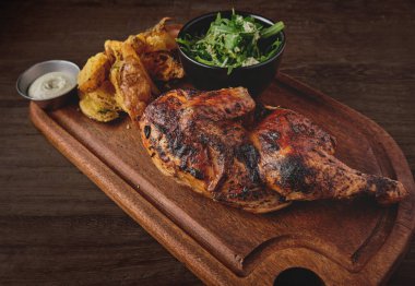 Peru yemeği, Pollo a la brasa veya kızarmış sarı patatesli yarım tavuk ve roka salatası, ahşap tahta. Seçici odak