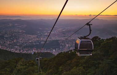 Modüler kabinler parlak gökyüzüne karşı teleferik, bulutlar dağlar. Waraira Repano Ulusal Parkı Caracas Venezuela 'daki deniz seviyesinden 1020 metre yükseklikte..