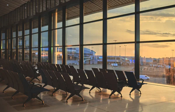 Puste Krzesła Hali Odlotów Widokiem Zachód Słońca Zamazany Samolot Tle — Zdjęcie stockowe