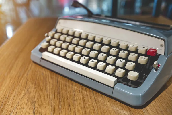 Retro old typewriter on blur background and front of wooden table. Vintage concept