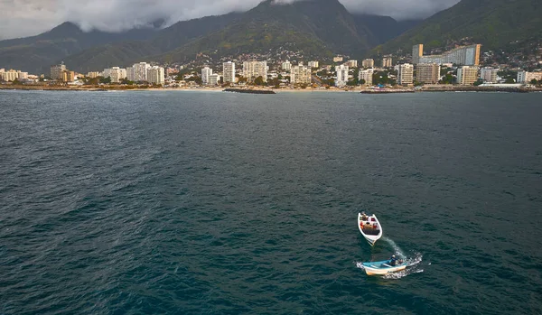 Aerial view of traditional fishing boat in Caraballeda with crystal clear turquoise sea, La Guaira. Venezuela.