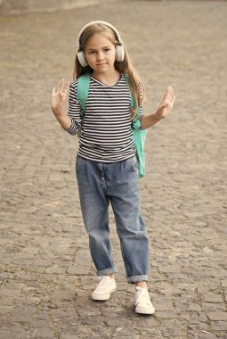 Macera benim en iyi terapim. Dışarıda sırt çantası taşıyan sevimli bir çocuk kulaklık takıyor. Müzik dinliyor. Modern teknoloji. Seyahat ve macera. Seyahat şarkısını tekrar tekrar çal