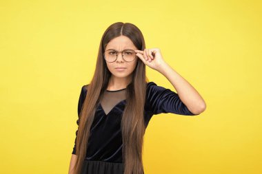 İnekler koruyucu giyiyorlar. Ciddi bir genç kız, görme bozukluğu yüzünden gözlük takıyor. Çocuk çalışmaya hazır. Çocuk okula geri döndü. çocukluk mutluluğu. Gözlükle çok şık görünüyorsun. Neden olmasın?