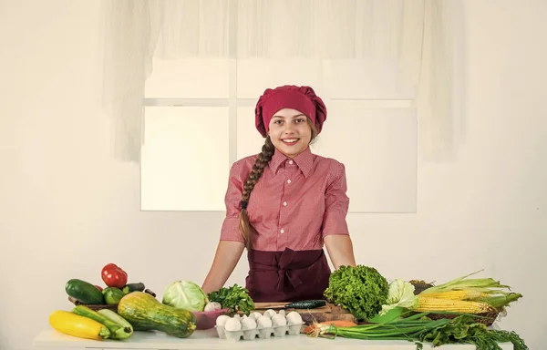 Glad liten flicka i kock hatt och förkläde i köket, bantning — Stockfoto
