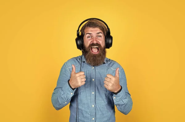 Kaukasiska hipster med skägg och elegant hår i headset med tumme upp, framgång — Stockfoto
