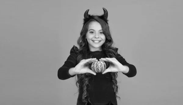 Menina feliz usar chifres do diabo segurando abóbora para criar jack o lanterna no dia das bruxas, amor halloween — Fotografia de Stock