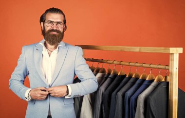 Her zaman şık. Tarz ve insan konsepti. Yakışıklı, sıradan giyimli, takım elbiseli ve seçici bir adam. Askıda duran şık erkek kıyafetleri. İş modası tarzı. kuru temizleme servisi