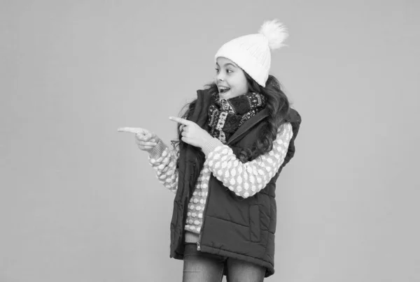 Publicidade roupa térmica. menina adolescente feliz usar roupas quentes. moda de criança de inverno. criança com cabelo encaracolado em tricotado chapéu poiting dedo. atividade de Natal estilo estação fria. felicidade infantil — Fotografia de Stock