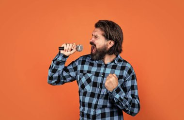 Ses ısıtması. Karaoke kulübündeki vahşi adam. Erkek mikrofonla şarkı söylüyor. Partideki yakışıklı hippi. Müzik. Olgun bir adam şarkı söyler. Ses sınıfları. Müzik tarzı. Sakallı adam mikrofonda şarkı söylüyor.