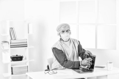 Koronavirüse maruz kalma riski var. İşçi dezenfekte bilgisayarı. Temiz ve sıkça temas edilen yüzeyler. Kişisel hijyen. Temizlik ve Dezenfeksiyon. Koronavirüsten korumak için maske takıyor. Çok hijyenik.