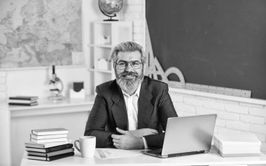 Okul projesi. Erkek işçi okul öğretmeni sınıfta. Yakışıklı hippi olgun eğitimci. Mesafe öğrenme. Yorgun hissediyorum. Kronik yorgunluk sendromu. İlk olarak yıl içinde kaç kredi alınacağını hesapla