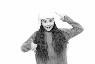 Malzeme açısından. Noel tatili aktivitesi. Çocukların giydiği rahat süveter beyazın üzerindeydi. Soğuk kış havası. Çocuklar için kalın kıyafetler ve aksesuar modası. Kürk şapkalı ve eldivenli küçük bir kız.