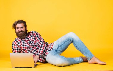 İşçi portresi. iş dünyasındaki modern teknoloji. Çevik iş. Dijital yaşam tarzı kavramı. Bilgisayarda çalışan olgun bir öğrenci. Adam defter üzerinde çalışıyor. İnternetten alışveriş. Neşeli hippi bilgisayar kullanıyor