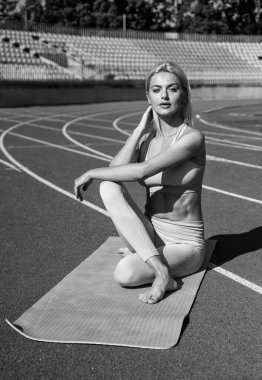 Yoga hocası. Spor başarısı. Esneklik kavramı. Fitness sporu modası. Sağlıklı beslenme. Yoga pozisyonunda sportif bir kadın. Stadyum spor salonunda esnek bir kadın. Bayan antrenör esneme egzersizi yapıyor.