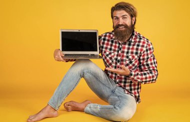 Bilgisayar ustası ürünü sunuyor. Dijital yaşam tarzı kavramı. Bilgisayarda çalışan olgun bir öğrenci. Adam defter üzerinde çalışıyor. İnternetten alışveriş. Neşeli hippi bilgisayar kullanıyor. iş dünyasındaki modern teknoloji