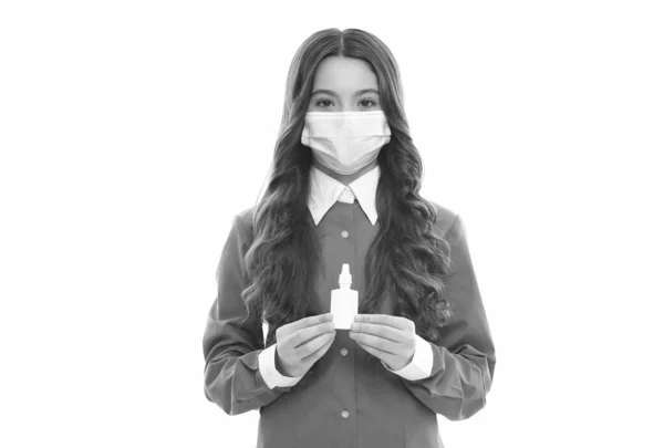 Een meisje met een masker houdt neusdruppels vast. kind met neusspray. loopneus coronavirus symptoom. Griep sars therapie. Covid symptomatische behandeling. risico op een viruspandemie. kind gebruikt effectieve geneesmiddelen — Stockfoto