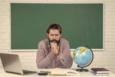 Vahşi sakallı adam hasta olduğu için sınıfta çalışıyor. Koronavirüs salgını sırasında muayeneye hazırlanın. Üniversite hocasının karantinaya ihtiyacı var. Okula dönüyorum. gayri resmi eğitim. Öksürük hocası hasta.