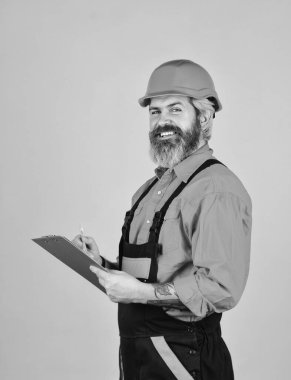 Kontrol listesi. Teftiş. Kontrol konsepti. Belgelerle ustabaşı. İnşaat malzemeleri teslimatı. Elinde dosya tutan kasklı bir adam bilgi arıyor. Tadilat için malzeme al. Sakallı depo görevlisi