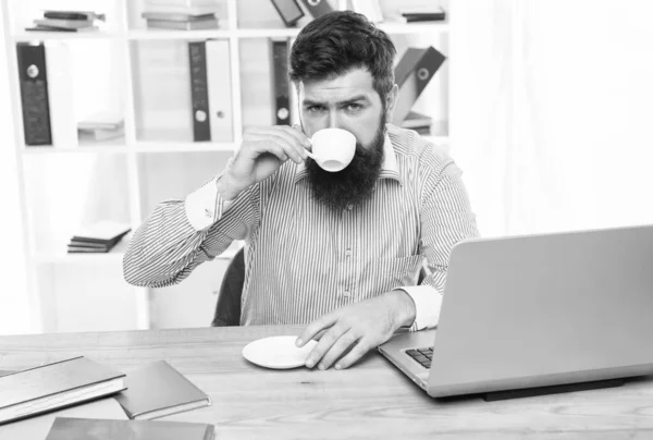 Пейте кофе, чтобы оставаться на задании. Бизнесмен наслаждается кофе-брейком на рабочем месте. Пьет горячую чашку утром. Жизнь в офисе. Кофеин делает его более продуктивным — стоковое фото