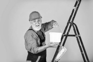 İnşaat onun hayatı. Boya silindirli bir zanaatkar. Ev boyama ve yenileme işi. Tamir aletleri yapıyorum. İnşaat alanında çalışan bir ressam. Son sınıf öğrencisi merdivende paten kullanıyor. Apartmanda çalış