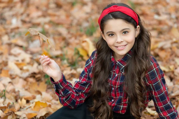 Teenager-Mädchen in Schuluniform halten Herbstblatt. Porträt eines fröhlichen Kindes — Stockfoto