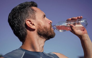 Sakallı adam antrenman, spor ve su içtikten sonra susadığı için su içiyor.