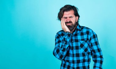 Sakallı ve bıyıklı yakışıklı hippi diş ağrısı ve stomatolojiden muzdarip.