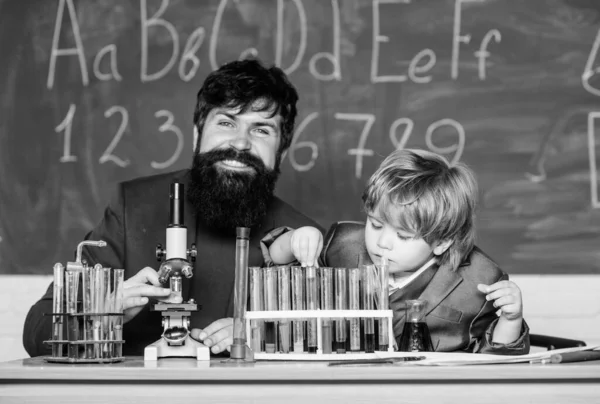 Um miúdo a aprender química no laboratório da escola. pai e filho na escola. Professor com rapazinho. De volta à escola. Cientista universitário a estudar ciências. Quanto maior a ilha de aprendizagem. — Fotografia de Stock