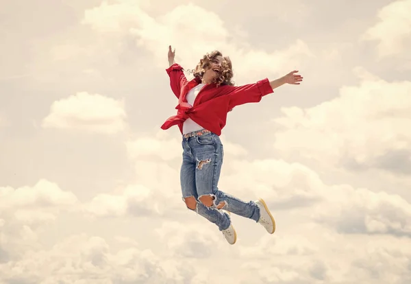 Bonne enfance. Un enfant souriant qui saute si haut. insouciante et joyeuse. style gosse mode. adolescente sur fond de ciel extérieur. Le gamin hipster saute. heureux jour des enfants — Photo