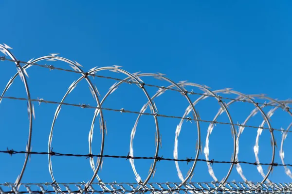highly protected prison wall with barbed wire fence. steel grating fence